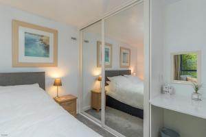 a bedroom with a bed and a glass wall at Melin-Dwyfor in Criccieth