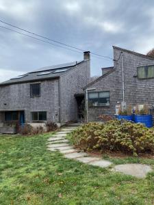 een grijs bakstenen huis met een grasveld bij Wellfleet Home in Wellfleet