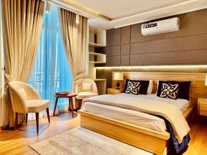 Un dormitorio con una cama tamaño king y una silla. en The Holton Stays by Bayti, en Rawalpindi