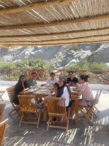 un gruppo di persone sedute a un tavolo di San Jerónimo River Lodge a Lunahuaná