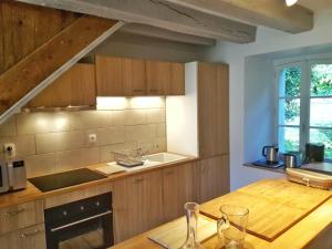 a kitchen with wooden cabinets and a wooden table at L'Orangerie in Bacilly