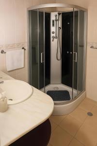 a bathroom with a glass shower with a sink at Tiny apartment near the airport in Ponta Delgada