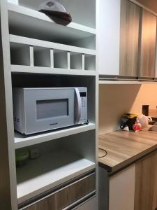 a microwave oven sitting inside of a kitchen at Apartamento estiloso in Ubatuba