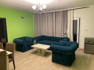 Una sala de estar con dos sofás azules y una mesa. en St Davido, en Douala