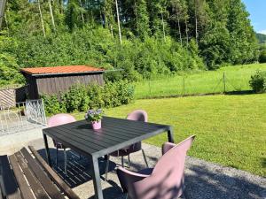 a black table with pink chairs and a table with at Salzkammergut Homes Gmunden - Haus im Grünen, Ruhe, großer eingezäunter Garten - ideal für Familien und Hunde in Pinsdorf