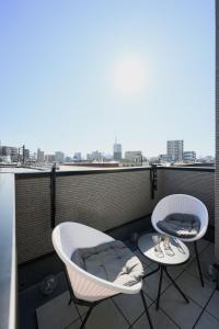 2 Stühle und ein Tisch auf dem Balkon in der Unterkunft Skytree View Riverside Terrace in Tokio