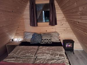 Un dormitorio con una cama en una cabaña de madera. en Ozy's place, en Kamnik