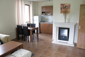 ein Wohnzimmer mit Tisch und Kamin in der Unterkunft Апартамент в Лъки Пампорово комплекс in Pamporowo