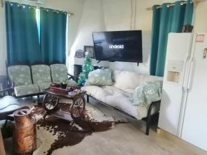 un soggiorno con un divano e una TV di Casa playa Lago Merin a Lago Merin