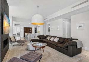 a living room with a brown couch and a table at High-end Coastal Escape in Sunny Isles Beach