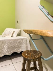 un tabouret assis à côté d'un lit dans une pièce dans l'établissement Pousada da Ana Maria, à Nobres