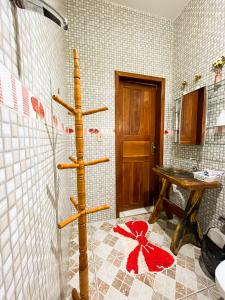 une salle de bain avec une barre en bois dans la douche dans l'établissement Pousada da Ana Maria, à Nobres