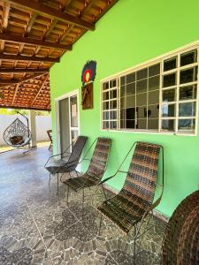 Cette chambre est dotée de chaises et d'un mur vert. dans l'établissement Pousada da Ana Maria, à Nobres 2 autres photos