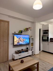 ein Wohnzimmer mit einem Flachbildfernseher an der Wand in der Unterkunft Cozy 2Rooms in Popeşti-Leordeni