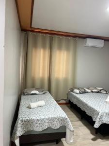 una stanza con due letti e una finestra di Pousada Bella Pantano a Pântano Grande