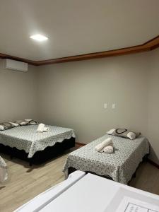 een kamer met twee bedden in een kamer bij Pousada Bella Pantano in Pântano Grande