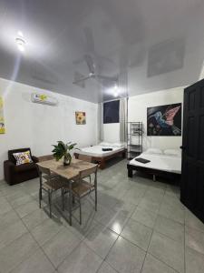 una sala de estar con dos camas y una mesa en Pelíkano Uvita, en Uvita