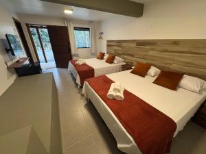 a hotel room with two beds with shoes on them at Casa Passarinho - Vale do Capão in Vale do Capao