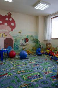 ein Zimmer mit einem Spielbereich für Kinder mit Spielzeug auf dem Boden in der Unterkunft Апартамент в Лъки Пампорово комплекс in Pamporowo