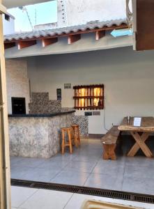 a room with a counter and a table and benches at Hospedagem Vermont in Maringá
