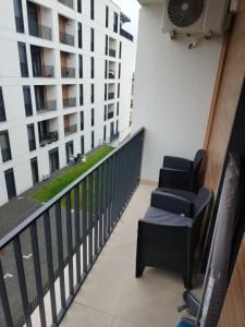 a balcony with two chairs and a building at Apartman Smaragd in Loznica
