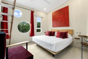 Schlafzimmer mit einem Bett mit roten Kissen und einer Leiter in der Unterkunft Pierre and Colors TAMARINDO Adults only in Tamarindo