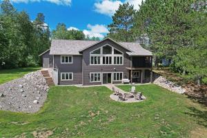 una casa con un ampio giardino con una casa di Northwoods WI 6BR Lakefront Cabin Retreat on Lake Nokomis - Minnohawk Lodge a Tomahawk