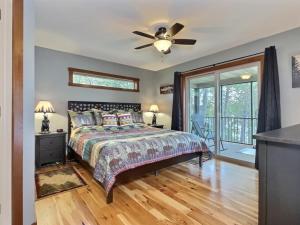 una camera da letto con un letto e un ventilatore a soffitto di Northwoods WI 6BR Lakefront Cabin Retreat on Lake Nokomis - Minnohawk Lodge a Tomahawk Altre 77 foto