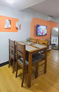 a dining room with a table and chairs at Bright & Airy Loft Cambridge Village Charm in Cainta