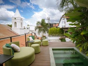 - une terrasse avec des chaises et une piscine dans un bâtiment dans l'établissement Hotel Boutique Casa Marichu con Piscina, Rooftop y Balcón en Casco Viejo, à Panama City