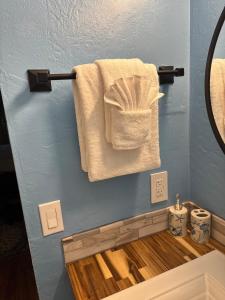 a bathroom with white towels on a blue wall at Stylish Studio Condo Near Magic Sands Beach in Kailua-Kona +19 photos