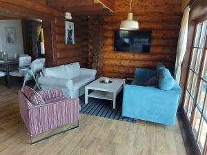 a living room with two couches and a tv at Zrub JESPER in Liptovský Trnovec