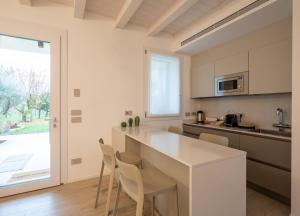 a kitchen with a white counter and a table at Residenza Galileo -affittacamere Padova sud in Albignasego