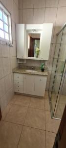 a bathroom with a sink and a mirror at Recanto do Nenei in Paraisópolis +24 photos