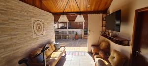 a living room with couches and a flat screen tv at Recanto do Nenei in Paraisópolis