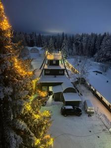 Vista aérea de uma casa na neve com luzes. em Hotel Yöpuu em Kemi