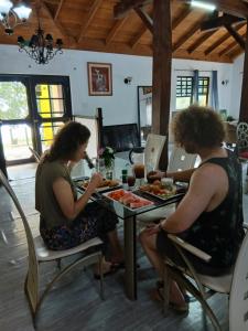 two women sitting at a table eating food at CROOКED TREE LODGE Belize in Crooked Tree