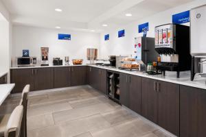 a large kitchen with brown cabinets and appliances at Best Western El Paso Airport Entrada Hotel in El Paso