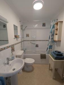 ein Badezimmer mit Waschbecken, Toilette und Badewanne in der Unterkunft SWANAGE WELL PRESENTED 2 BEDROOM APARTMENT CLOSE to BEACH in Swanage