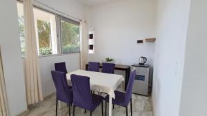 LamasVista Hermosa Lamas的一间设有白色桌子和紫色椅子的用餐室