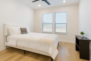 a white bedroom with a bed and two windows at Relaxing 1BR escape worker friendly A plus Location in Sherman