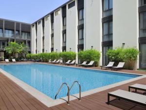 a swimming pool in front of a building at Mövenpick Hotel Tahlia Jeddah in Jeddah