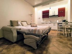 a bedroom with a bed and a couch and a kitchen at Dimoramica LTB in Foligno