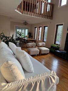 a living room with a white couch with pillows at Poconos Chalet -Kayaks- HotTub-Karaoke-Lake in East Stroudsburg