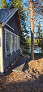 a small house with a ramp next to a tree at Aurora river cabin in Kiruna