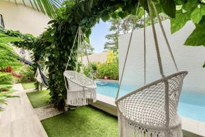 ein Schaukelstuhl vor einem Swimmingpool in der Unterkunft Pierre and Colors TAMARINDO Adults only in Tamarindo