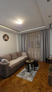 a living room with a couch and a table at Stan na dan Alexa sa free parkingom in Novi Sad