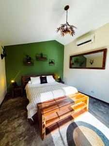 una camera da letto con un letto e una parete verde di Coronado Hideaway with Private Pool a Las Lajas