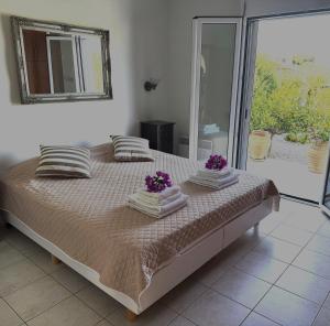 a bedroom with a bed with purple flowers on it at Villa Athina in Pangalochori +21 photos