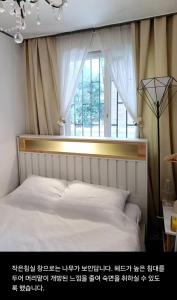 una camera da letto con un letto davanti a una finestra di Urban a Suwon Altre 14 foto